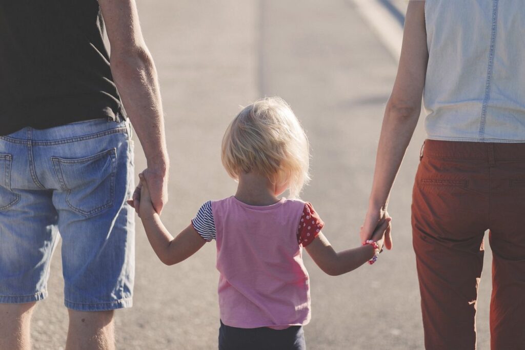 Free parent holding child's hand